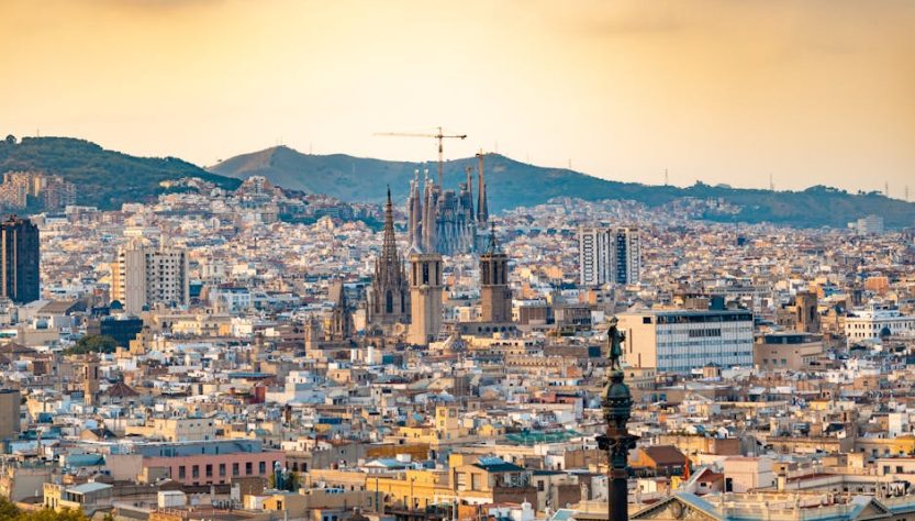 A breathtaking aerial view of Barcelona featuring the iconic Sagrada Familia at sunset.
