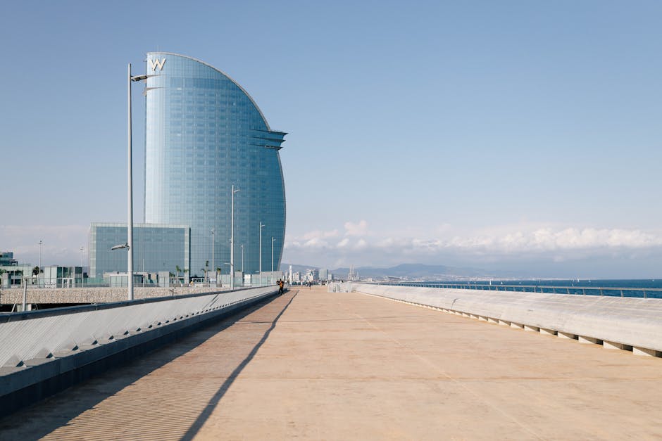 Iconic W Barcelona hotel with stunning design against a clear sky on a serene pier setting.