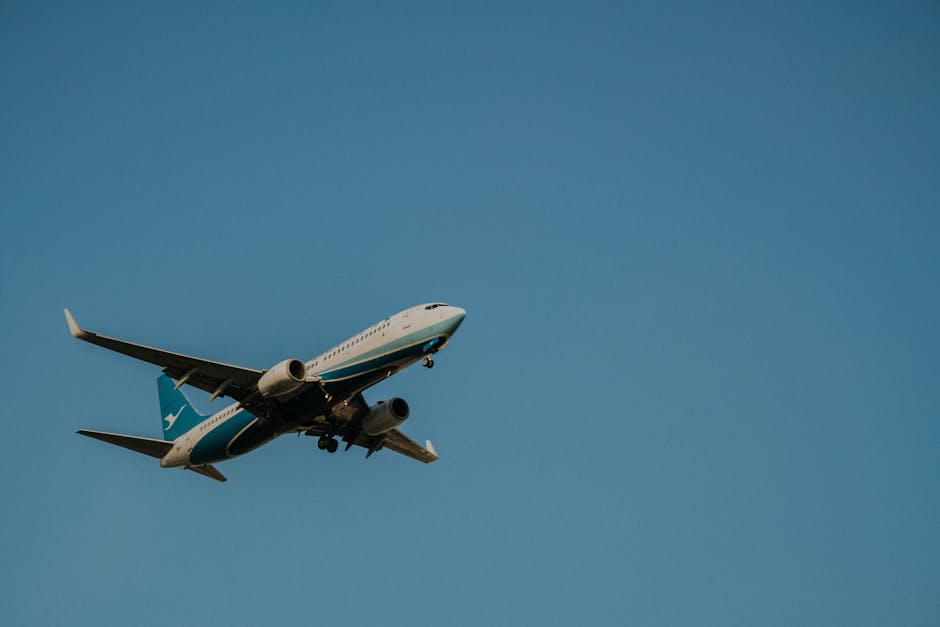 Low angle shot of a commercial airplane flying against a clear blue sky.