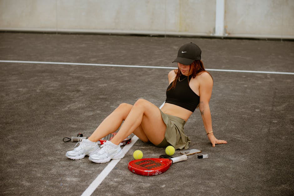 A young woman in sportswear relaxes on a padel tennis court in Puebla, Mexico.